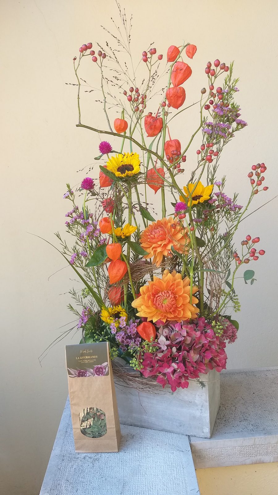 Composition haute de tournesols, gerberas et physalis